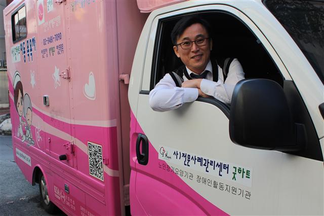 김성국 굿하트전문사례관리센터 대표가 29일 이동목욕봉사 차량 안에서 밖을 내다보며 미소를 짓고 있다. 굿하트 제공
