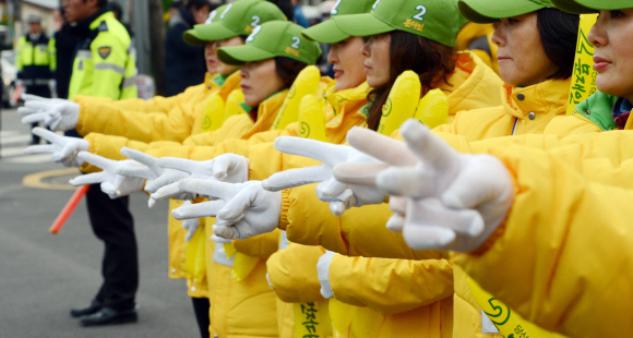 “2번을 찍어주세요”  문재인 민주통합당 후보 유세단이 29일 전남 여수 서시장에서 노란 점퍼를 입고 기호 2번을 뜻하는 V자를 그리며 시민들에게 한 표를 호소하고 있다. 여수 정연호기자 tpgod@seoul.co.kr