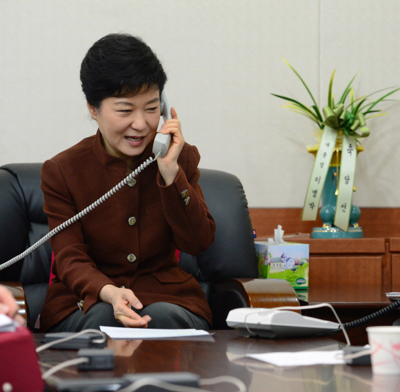 오바마와 통화  박근혜 대통령 당선인이 21일 서울 여의도 새누리당사 집무실에서 버락 오바마 미국 대통령과 전화 통화를 하고 있다. 당선인 뒤로 이명박 대통령이 보낸 당선 축하 난이 놓여 있다. 이호정기자 hojeong@seoul.co.kr 