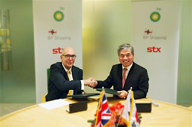 신상호(오른쪽) STX조선해양 사장이 최근 존 리지웨이 BP시핑 최고경영자(CEO)와 유조선 13척을 발주하는 계약을 체결한 뒤 악수하고 있다.  STX 제공