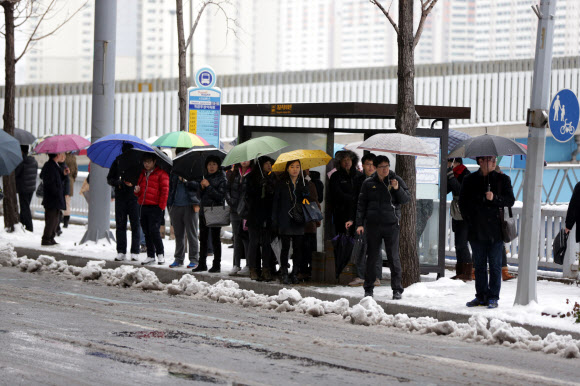 버스야 언제 오려나 28일 부산에 눈이 내리면서 곳곳에 출근길 교통이 마비됐다. 부산 부산진구 개금주공아파트 앞 버스정류소에서 시민들이 버스를 기다리고 있다.  연합뉴스