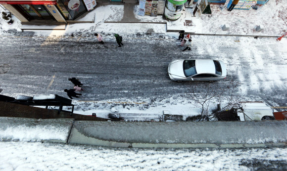 밤새 많은 양의 눈이 내린 30일 오전 서울 대학로에서 시민들이 빙판길을 조심스럽게 걷고 있다. 연합뉴스