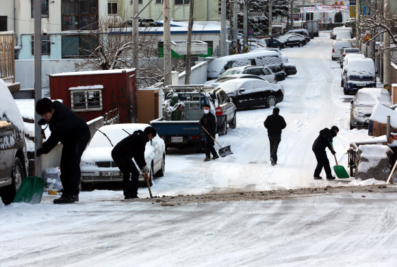 눈을 치우자 2012년 마지막 날인 31일 광주·전남지역에 많은 눈이 내려 광주 서구의 한 골목길에서 시민들이 제설작업을 하고 있다.  연합뉴스