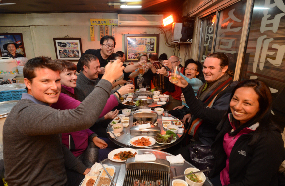 한국의 음주문화 체험을 위해 지난 18일 저녁 서울 종로의 한 고깃집에 모인 외국인 관광객들이 소주잔을 부딪치며 건배를 외치고 있다. 안주영 기자 jya@seoul.co.kr