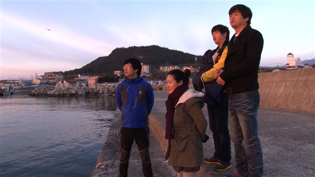삼형제와 한 지붕 아래 사는 20대 주부 세미(가운데)씨가 가족들과 함께 바닷가에서 지평선을 바라보고 있다.  KBS 제공
