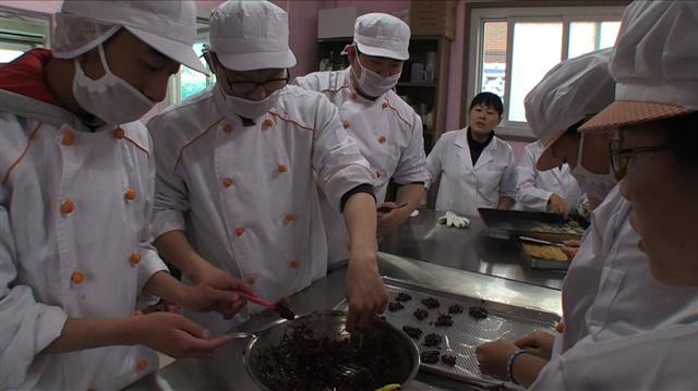 지적 장애인들의 일터인 카페 ‘다울’에서 종업원들이 쿠키 반죽을 만들고 있다. EBS 제공