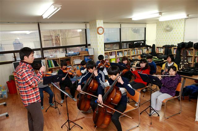 23일 울산 남구의 A 아동지원센터에서 아이들이 음악 수업을 받고 있다. 이곳은 남구 거점센터인 데도 129㎡의 비좁은 공간에 다목적 학습장과 도서실, 식당(주방), 사무실 등이 운영되고 있을 뿐 아니라 이용 아동도 29명이나 돼 복잡하다.