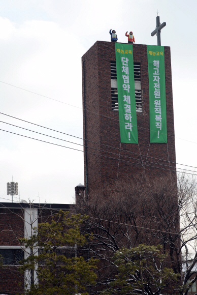 재능교육의 해고자 2명이 6일 오전 서울 종로구 혜화동성당 내 15m 높이 종탑에 올라 해고자 전원 복직 등을 요구하며 고공농성을 벌이고 있다. 박지환 기자 popocar@seoul.co.kr