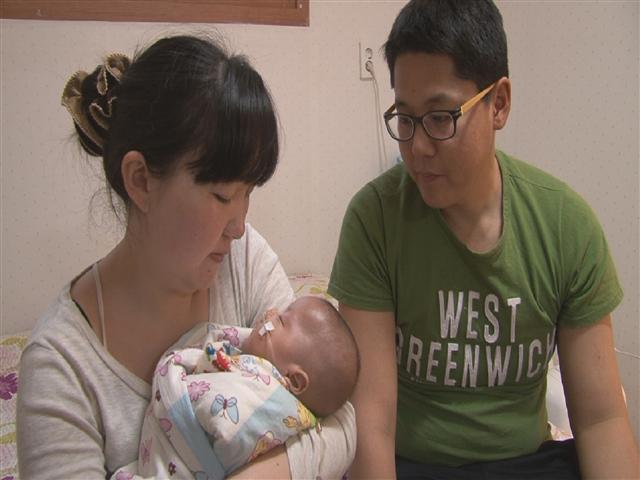 엥흘렌의 부모가 초극소저체중아로 태어나 각종 병과 힘겨운 사투를 벌이는 아이를 안쓰럽게 쳐다보고 있다. SBS 제공 