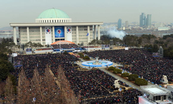 국회의사당 가득 메운 시민  25일 오전 서울 여의도 국회의사당 광장에서 제18대 대통령 취임식이 열렸다. 시민들이 식장을 가득 메운 가운데 박근혜 대통령의 선서 직후 예포대가 군 예식령에 따라 21발의 예포를 발사하고 있다. 정연호 기자 tpgod@seoul.co.kr