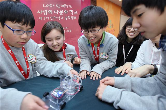 지난해 2월 서울 송파구 방이동 올림픽파크텔에서 열린 ‘LG 사랑의 다문화학교’ 2기 입학식 및 방학캠프에서 다문화가정 학생들이 카이스트 대학생 멘토와 함께 전기분해 수소 자동차를 제작하고 있다.  LG 제공