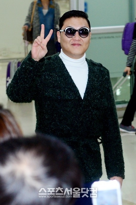 신곡 발표와 대규모 단독 콘서트를 앞둔 가수 싸이가 17일 오전 김포국제공항을 통해 귀국한 가운데 팬에게 포즈를 취하고 있다.