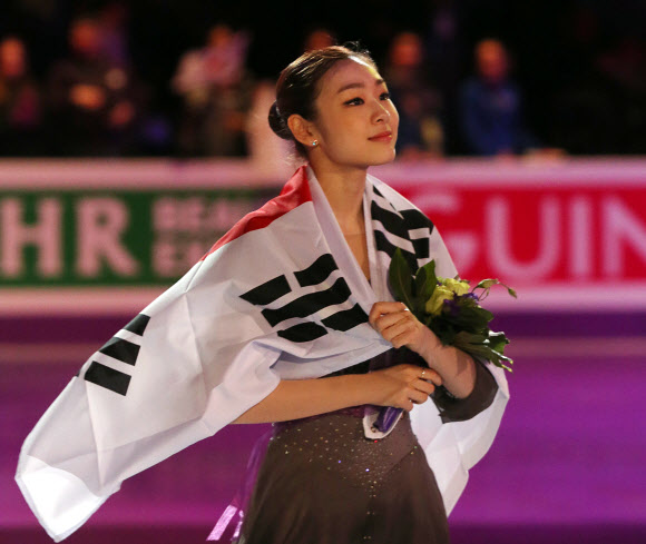 한국의 피겨여왕 김연아가 17일(한국시각) 2013 국제빙상경기연맹(ISU) 세계피겨선수권대회 여자싱글에서 우승한 후 태극기를 몸에 두르고 경기장을 돌고 있다.  연합뉴스