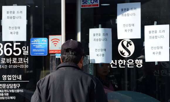 주요 방송사 및 일부 은행의 전산망이 마비된 20일 오후 서울 동대문구 제기동에 위치한 신한은행 지점 입구에 전산장애를 알리는 안내문이 붙어 있다. 도준석 기자 pado@seoul.co.kr
