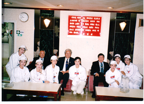 2002년 부산 아시안게임에 참가한 북한 선수단이 숙소로 사용한 만경봉호에 초대받아 장웅(뒷줄 왼쪽에서 세 번째) 북한 IOC 위원, 미녀 응원단과 포즈를 취하는 모습.