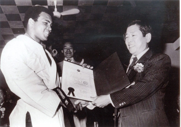 김운용 전 IOC 부위원장이 자랑스러워 하는 한국 스포츠의 역사적인 장면들을 모았다. 1976년 5월 28일 국기원을 방문한 미국의 복싱 전설 무하마드 알리(왼쪽)에게 태권도 명예 단증을 수여하는 모습.