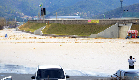 12일 오후 경북 경주시 안강읍 산대리 산대저수지 둑이 터져 저수지 물이 도로로 넘쳐나고 있다. 연합뉴스