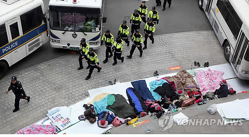 진주의료원 해산 조례 처리를 위한 경남도의회 본회의날인 18일 오전 경남도의회 앞 마당에서 진주의료원 지키기 공공의료강화 범국민대책위원회 노조원들이 경찰차벽을 바람막이 삼아 밤샘 노숙을 벌이고 있다. 연합뉴스