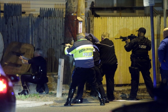 보스턴 마라톤대회 테러 사건의 용의자를 추격하고 있는 미국 경찰이 2013년(현지시간) 보스턴 외곽 워터타운에서 총을 겨누고 있다. 워터타운 AP 연합뉴스