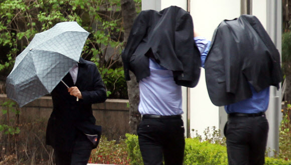 23일 오후. 갑자기 비가 내리자 회사원들이 양복 상의로 비를 피하고 있다. 연합뉴스