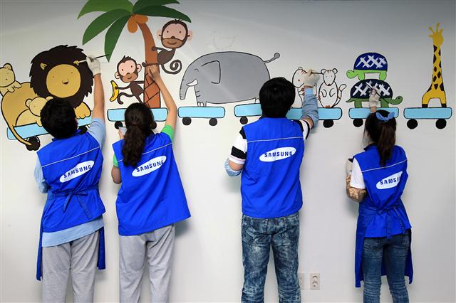 제일모직 신입사원들이 지난해 9월 창립기념일을 맞아 서울 강남구 삼성동의 서울시립드림센터에서 벽화그리기 봉사활동을 하고 있다. 제일모직 제공