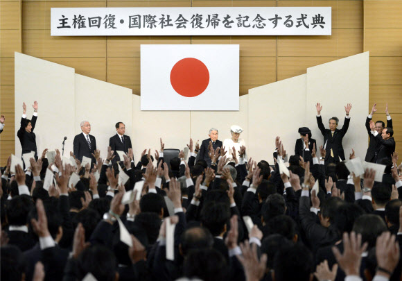 아베 신조(왼쪽에서 첫 번째) 일본 총리가 28일 도쿄에서 열린 ‘주권 회복의 날’ 기념식에서 참석자들과 함께 아키히토(왼쪽에서 네 번째) 일왕과 미치코 왕비를 향해 두 팔을 들어 올리며 만세 삼창을 하고 있다.  도쿄 AP 연합뉴스