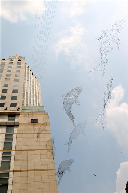 김창환 작가의 상어들이 백화점 건물 사이에 설치된 장면. 롯데갤러리 제공