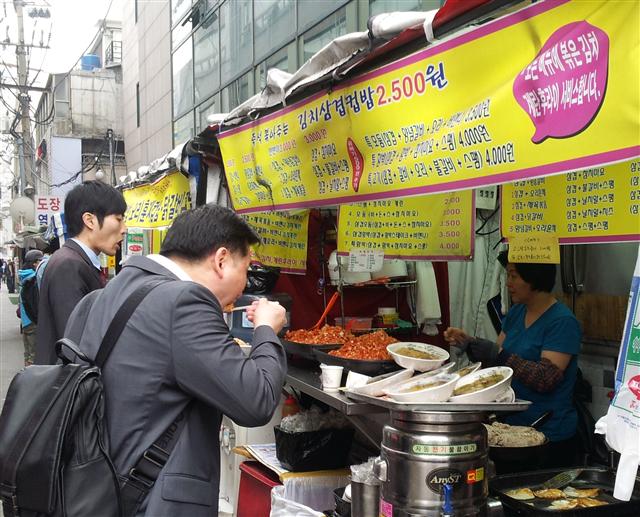 10일 서울 노량진 컵밥 포장마차에서 직장인들이 가격이 싼 컵밥을 먹고 있다.