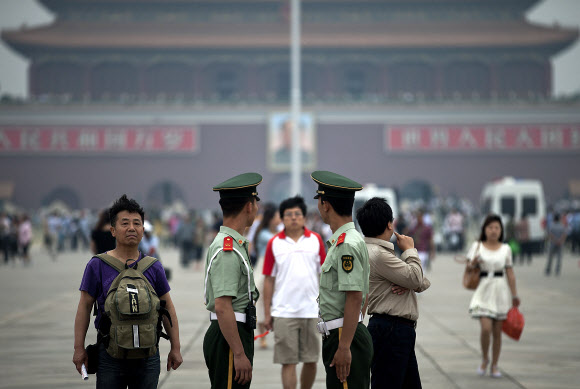 중국 톈안먼 사태 24주년인 4일 베이징 톈안먼 광장에서 공안들이 시민들을 주시하며 경비를 서고 있다. 베이징 AP 연합뉴스