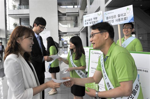 환경의 날을 앞두고 4일 인천 송도 포스코건설 사옥으로 출근하는 직원들이 그린워크 자가활동 점검표를 받고 있다. 포스코건설 제공