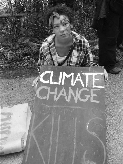 런던 기후 캠프에 참가한 한 여성이 기후 변화를 우려하는 플랜카드를 들고 있다.