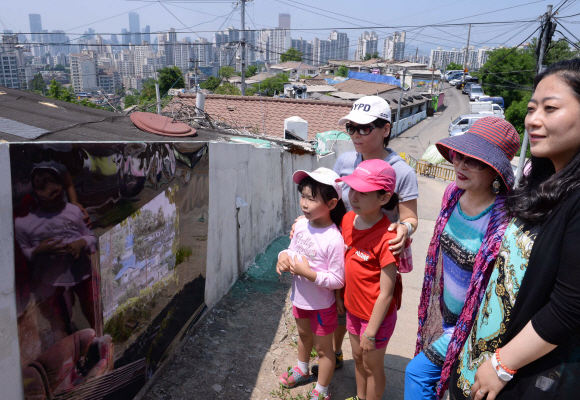 시민과 어린이들이 9일 개발예정지인 서울 상도2동 밤골 마을 골목길에서 열린 사진전에서 전시된 작품을 관람하고 있다. 