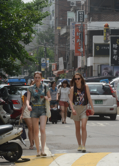 시원한 옷차림의 외국인 여행객들이 14일 서울 마포구 연남동 게스트하우스 거리를 걷고 있다.  안주영 기자 jay@seoul.co.kr