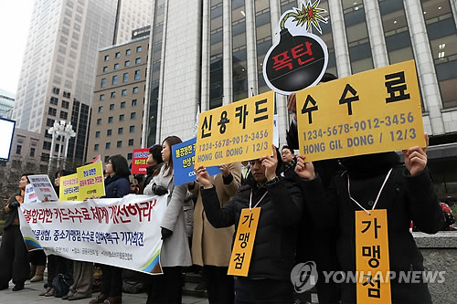 서울 중구 태평로 금융위원회 앞에서 열린 카드수수료 인하 촉구 기자회견에서 참석자들이 팻말을 들어보이고 있다.(자료사진) 연합뉴스