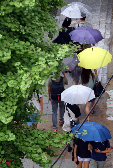7일 오후 서울 강남구 신사동 가로수길에서 시민이 우산을 쓰고 길을 가고 있다. 기상청은 이날 남부지방에서 중부지방으로 북상하는 장마전선의 영향을 받아 전국이 대체로 흐리다가 오후 늦게 비가 내린다고 밝혔다.  연합뉴스