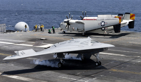 10일(현지시간) 미국 해군의 무인 전투기인 X47B(아래)가 버지니아주 노퍽 인근 해상에서 항공모함 조지 H W 부시호의 활주로에 착륙하고 있다. 노퍽 AP 연합뉴스 
