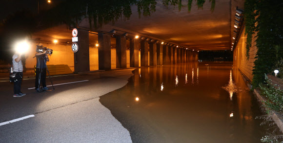 팔당댐 방류로 한강 수위가 상승함에 따라 15일 밤 서울 여의상류 IC 토끼굴 일대가 침수되어 교통이 통제되고 있다. 연합뉴스