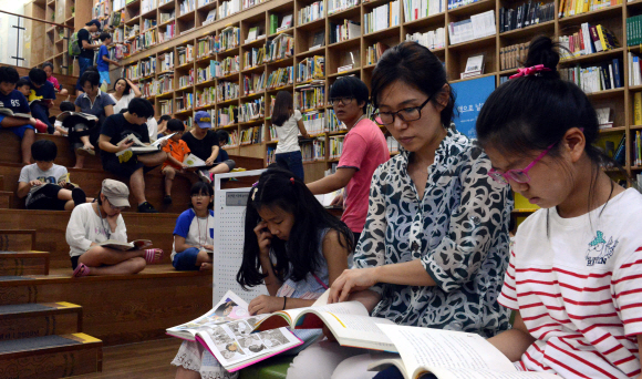 일요일인 28일 부모와 함께 서울 중구 서울도서관을 찾은 어린이들이 더위를 잊은 채 책을 읽고 있다. 이종원 선임기자 jongwon@seoul.co.kr