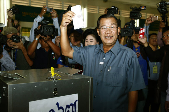 캄보디아 총선 투표가 28일 전국 1만 9000여개 투표소에서 진행된 가운데 훈 센 총리가 수도 프놈펜 남쪽 타크마우 마을 투표소에서 투표용지를 들어 보이며 웃고 있다. 프놈펜 AP 연합뉴스