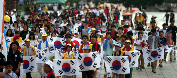 15일 충남 천안 독립기념관에서 열린 제68주년 광복절 경축식을 찾은 시민들이 태극기를 들고 걸어오고 있다. 연합뉴스