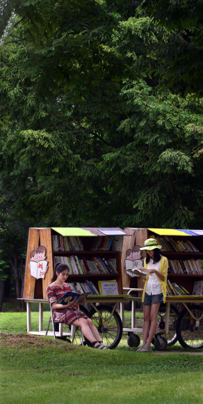 서울숲 공원의 중앙에 비치한 ‘책수레’에서 시민들이 책을 골라 보고 있다. 관리자도 없고 독촉 전화도 하지 않지만 회수율이 85%를 웃도는 ‘양심책수레’이다.  이종원 선임기자 jongwon@seoul.co.kr