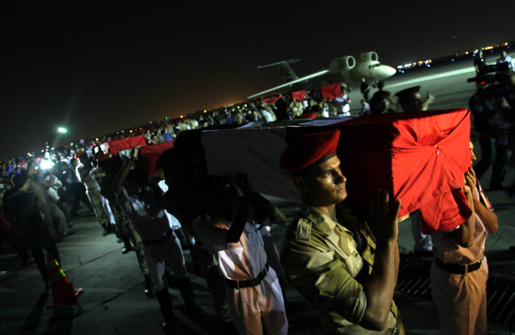 19일(현지시간) 이집트 시나이반도 라파 마을에서 무장 괴한의 공격을 받고 사망한 치안부대원 25명의 시신을 담은 관이 수도 카이로 알마자 군사 공항에 도착하자 군인들이 운구하고 있다. 카이로 AP 연합뉴스