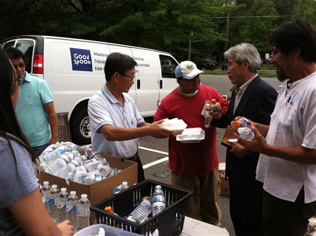19일 낮(현지시간) 미국 버지니아주 애넌데일의 한 공터에서 조영길(오른쪽에서 두번째) 목사 등 한인 자원봉사자들이 히스패닉계 빈민들에게 무료 점심을 나눠주고 있다.