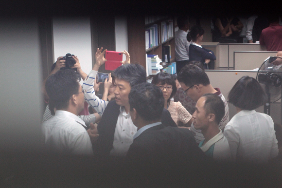 변호사가 잠시 자리를 비운 사이 수색을 계속하려는 국정원 직원으로 보이는 사람(뒷모습)과 수색을 중단하라는 김선동 의원 등 통진당 관계자들이 말다툼을 하고 있다. 2013.8.28 이호정