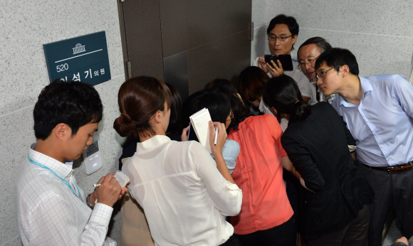 사무실 안쪽에서 국정원 직원들과 이 의원 보좌관들 사이에서 고성이 오가자 취재진이 문에 귀를 대고 이를 듣고 있다.  안주영기자 jya@seoul.co.kr