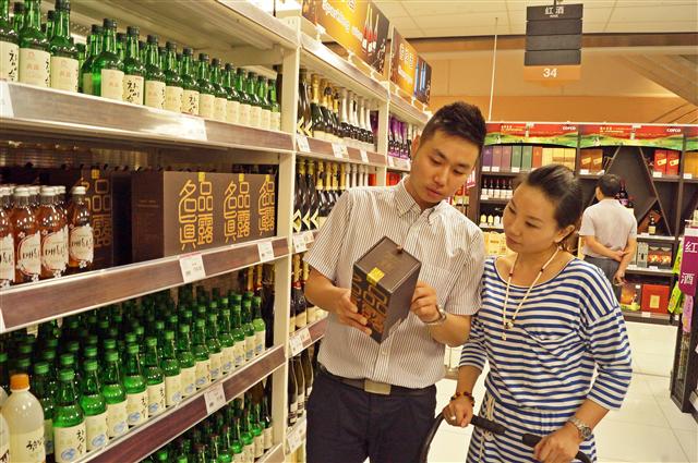 중국 베이징 차오양취 칭녠루의 대형마트 융왕차오스에서 현지인 고객들이 하이트진로의 ‘명품진로’를 살펴보고 있다. 이 술의 알코올 함량은 30도로 중국 전통주보다 낮은 것이 특징이다. 하이트진로 제공