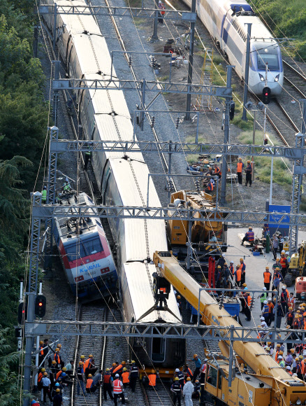 지난달 31일 대구역 무궁화호와 KTX의 충돌로 탈선한 열차를 코레일 관계자들이 1일 궤도로 올리는 작업을 하고 있다.  연합뉴스