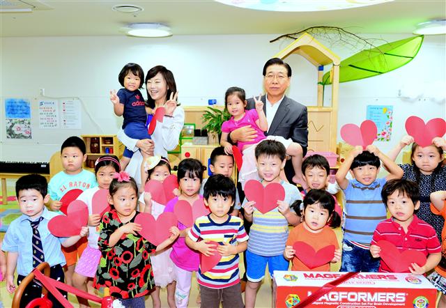 2일 서울 강남구 포스코센터의 직장어린이집을 찾은 조윤선(뒷줄 왼쪽에서 두 번째) 여성가족부 장관과 정준양(맨 오른쪽) 포스코 회장이 위탁 아동들과 사진 촬영을 하고 있다. 포스코 제공