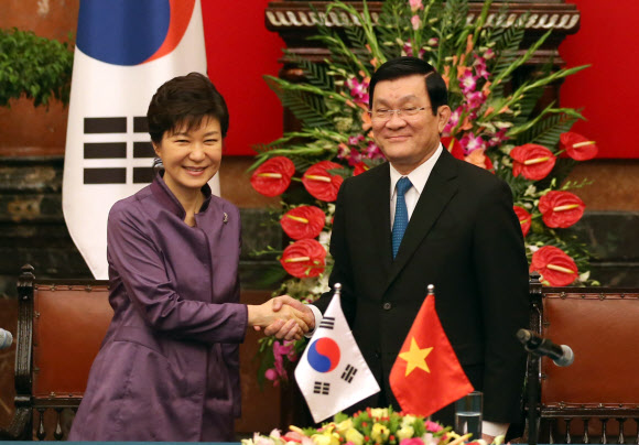 악수하는 한-베트남 정상 박근혜 대통령과 쯔엉 떤 상 베트남 국가주석이 9일 오후 주석궁에서 열린 공동기자회견을 마친뒤 악수하고 있다.  연합뉴스