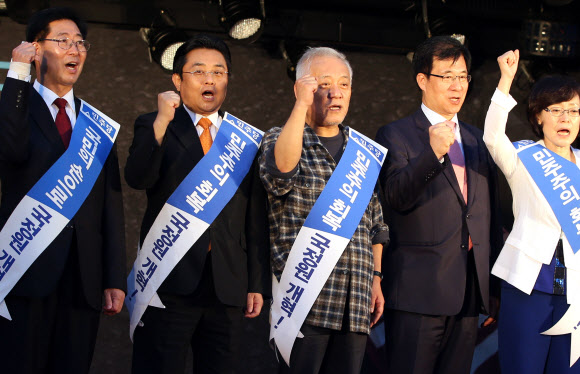 김한길(가운데) 대표를 비롯한 민주당 지도부가 13일 오후 서울광장에서 열린 ‘민주주의 회복과 국정원 개혁 촉구’를 위한 국민결의대회에 참석해 구호를 외치고 있다. 전병헌 원내대표는 이 자리에서 채동욱 검찰총장의 사퇴에 대해 “검찰 흔들기의 종결판”이라고 주장했다. 왼쪽부터 양승조 최고위원, 전 원내대표, 김 대표, 신경민·전혜자 최고위원. 연합뉴스